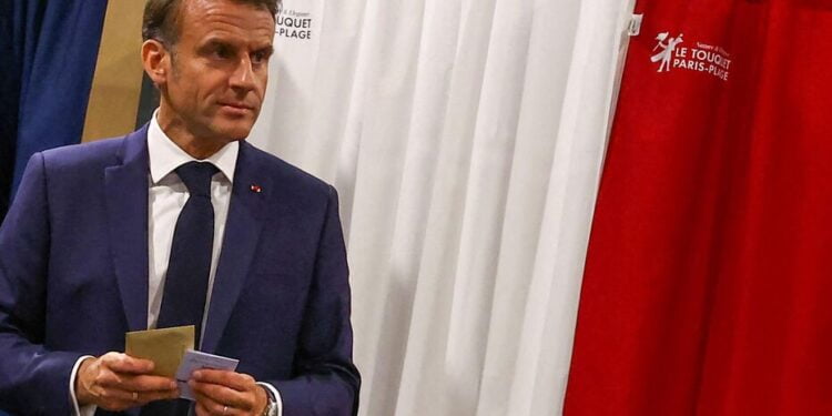 France's President Emmanuel Macron exits a polling booth, adorned with curtains displaying the colors of the flag of France, before casting his ballot for the European Parliament election at a polling station in Le Touquet, northern France on June 9, 2024. Voting began across Europe on June 9, 2024 on the final -- and biggest -- day of marathon EU elections, with balloting due in 21 countries, including France and Germany, where support for surging far-right parties is being tested. (Photo by Hannah McKay / POOL / AFP)