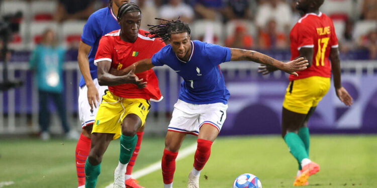 Paris 2024 Olympics - Football - Men's Group A - France vs Guinea - Nice Stadium, Nice, France - July 27, 2024. Moriba Ilaix of Guinea in action with Michael Olise of France. REUTERS/Raquel Cunha