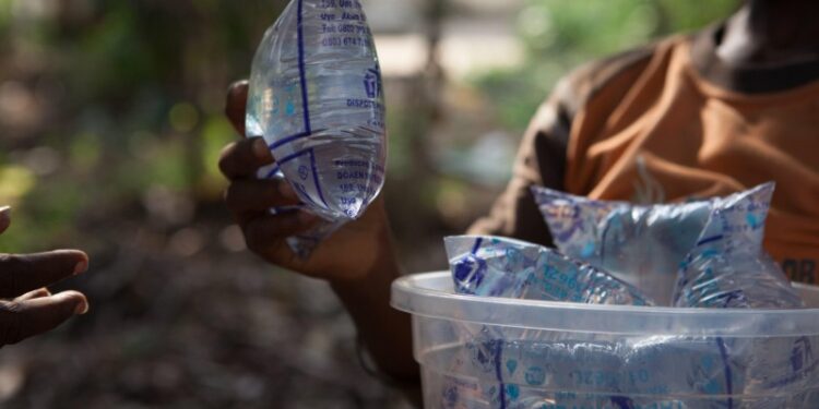 FWABX8 A boy selling sachets of purified water on the streets of Nigeria, Africa